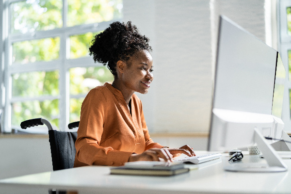 Happy young woman using desktop computer